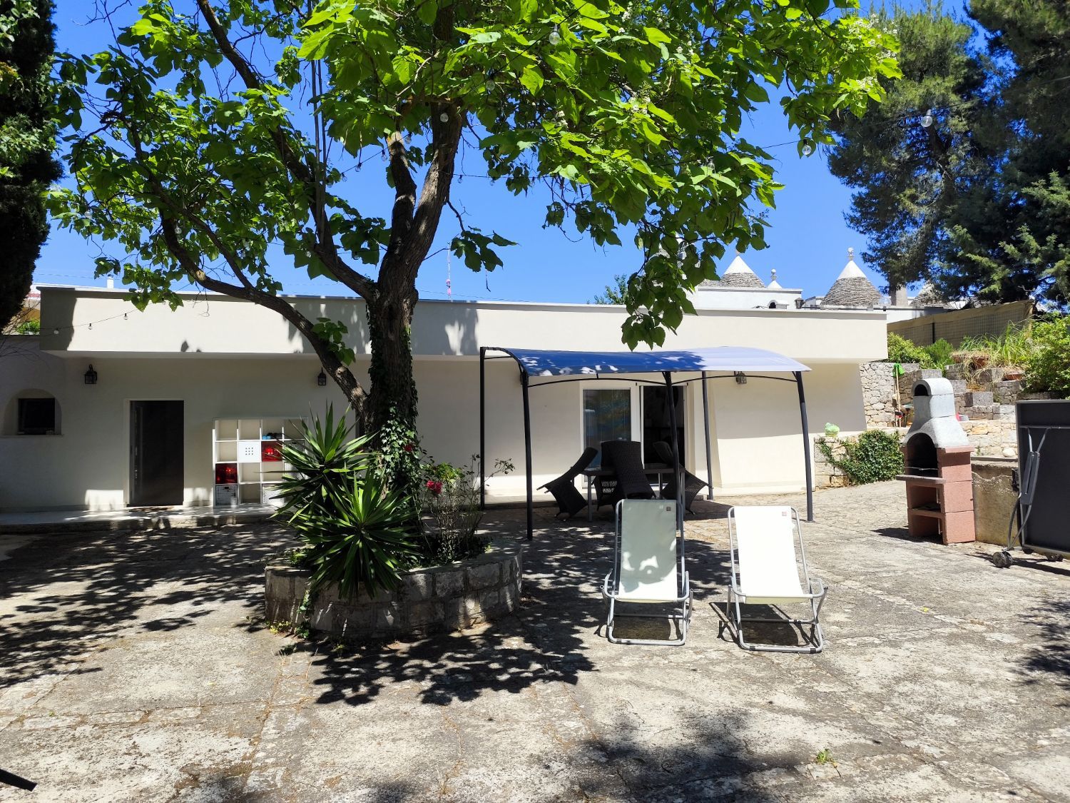Il cortile con le sdraio e i trulli sullo sfondo